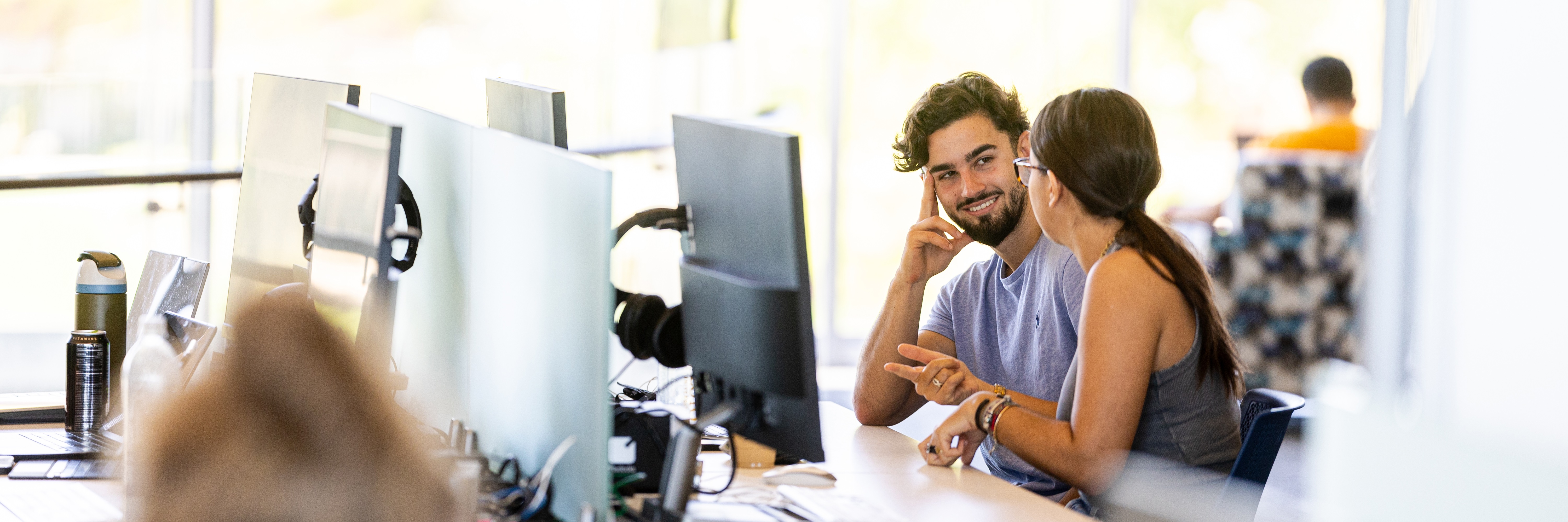 Students collaborating at computers in a campus lab